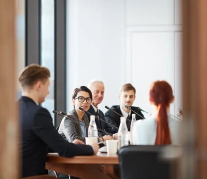 Group of people at meeting table with microphones